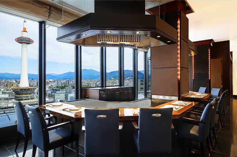 鉄板カウンターを囲む席から景色を楽しめる鉄板焼店の内観