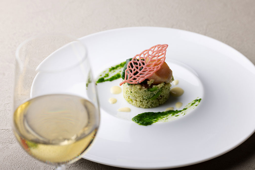 白い皿に美しく盛り付けられた前菜と白ワインのグラス