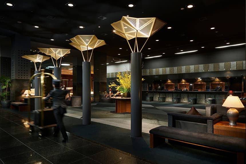 ホテルのロビーとフロント。ベルスタッフが荷物を運んでいる。