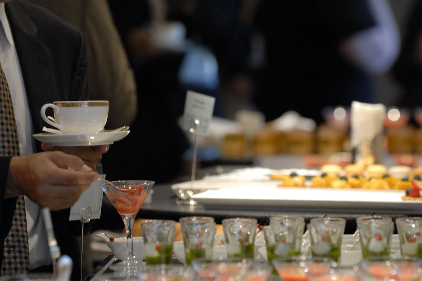 立食式の会場で食事を楽しむ人々。