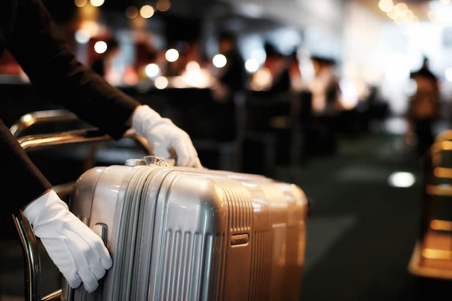 白手袋で丁寧にお客様の荷物を扱う手元