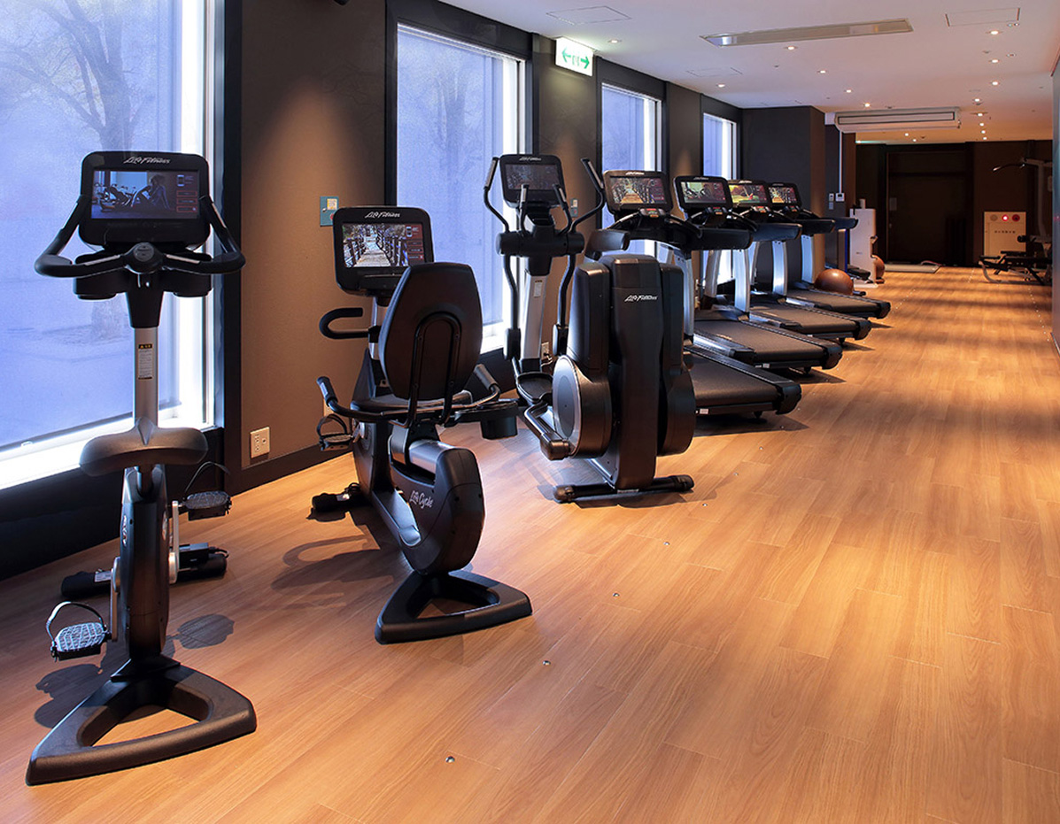 最新のトレーニングマシンが設置されたフィットネスジム。清潔で広々とした空間で、ランニングやサイクリングを楽しめる。