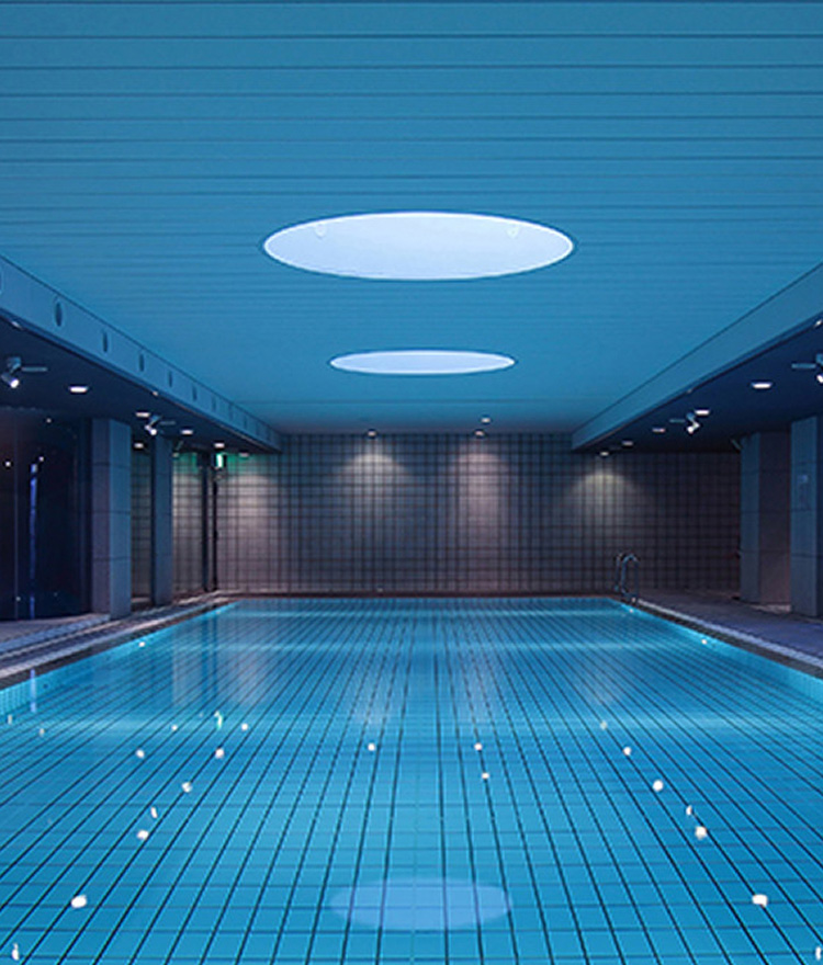 青い光に包まれた、神秘的で落ち着いた雰囲気の屋内プール。