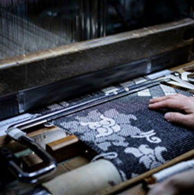 職人が織機で布地を織る作業風景