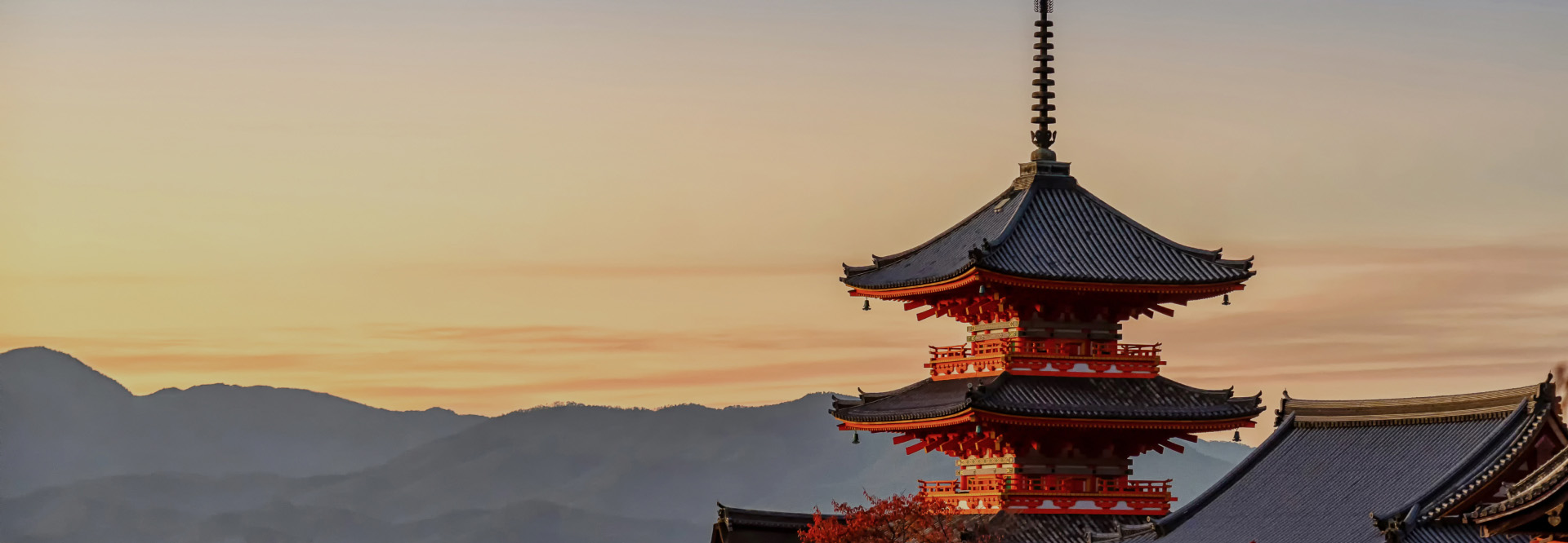 夕暮れの空を背景に、清水寺の鮮やかな朱色の三重塔を捉えた一枚。