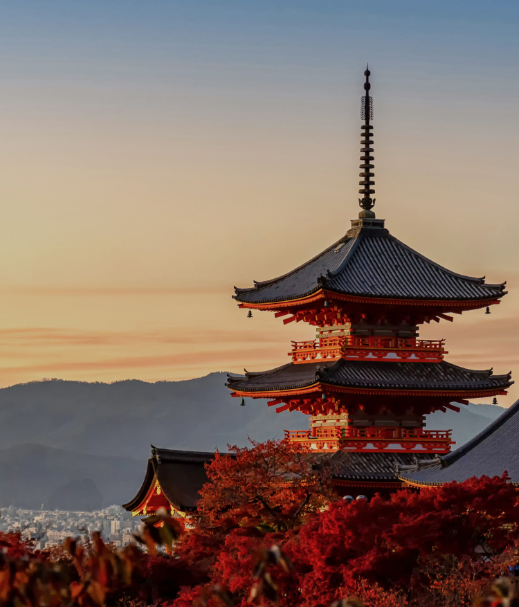 夕暮れの空を背景に、清水寺の鮮やかな朱色の三重塔を捉えた一枚。