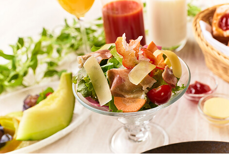 生ハムとレタスやトマトなど様々な野菜が混ざったサラダ。