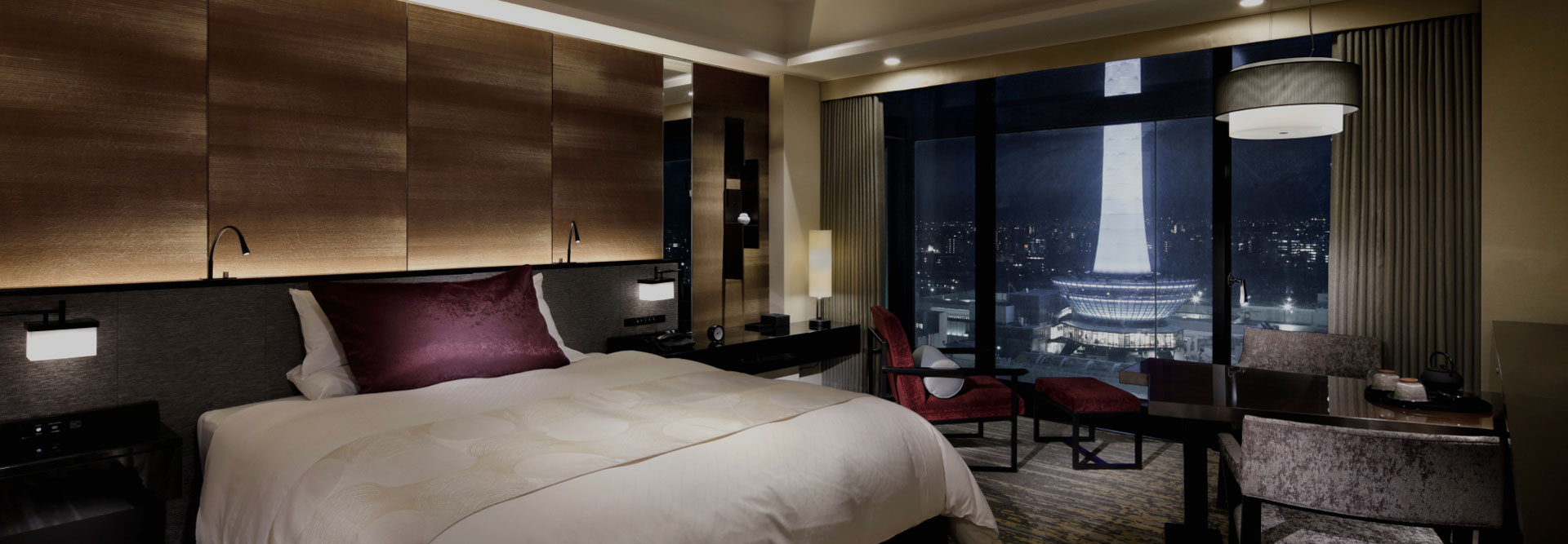 窓際にテーブルとソファがあるダブルベッドルーム、夜の雰囲気