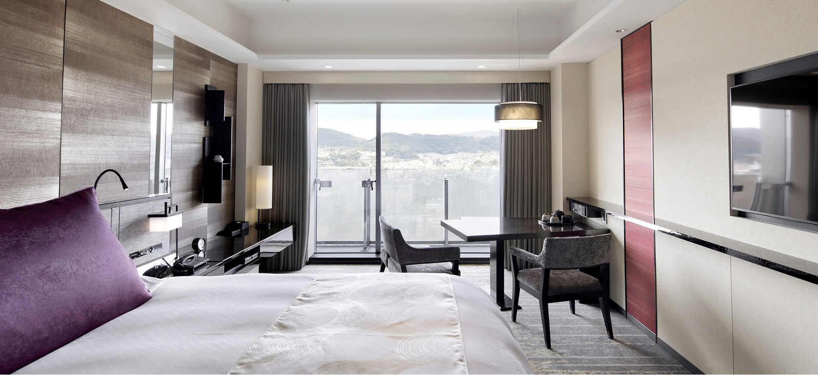 明るい内装で開放感のある、紫色のクッションが映えるダブルルーム