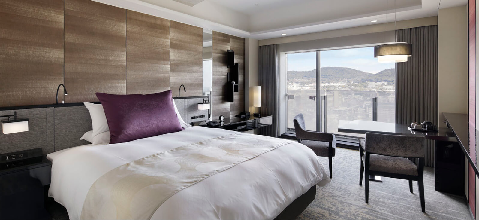 窓から自然光が差し込む、シンプルで落ち着いたインテリアの客室