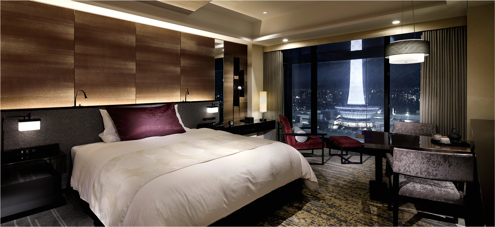 窓際にテーブルとソファがあるダブルベッドルーム、夜の雰囲気