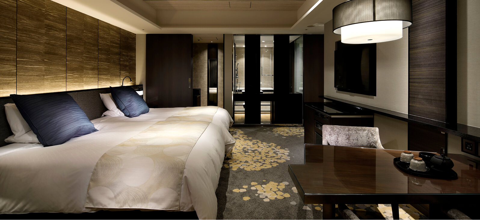 木目調の壁と青いクッションが印象的な高級感のあるツインルーム