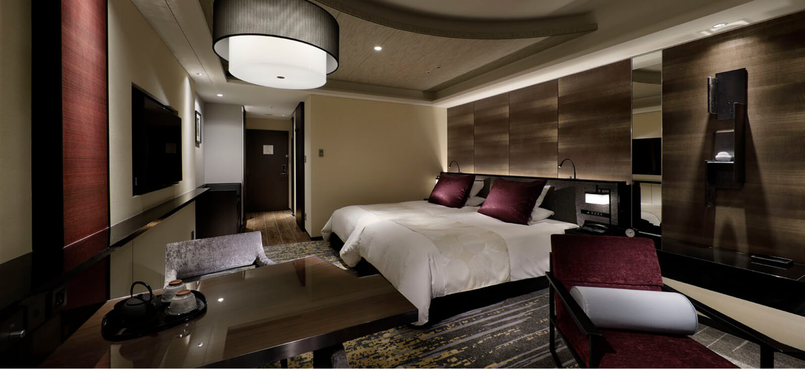 曲線天井が特徴的な、重厚な家具とダブルベッドのある洋室