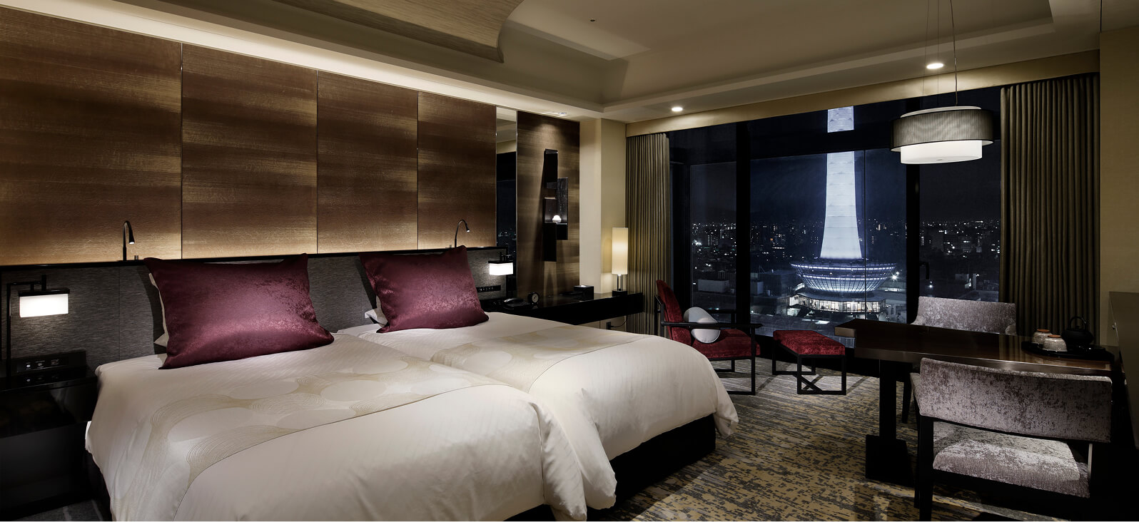 夜景が見える大きな窓とツインベッドのあるシックな洋室