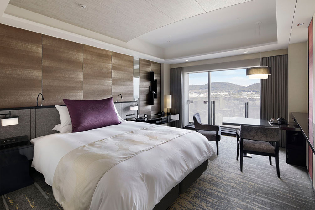 窓から自然光が差し込む、シンプルで落ち着いたインテリアの客室