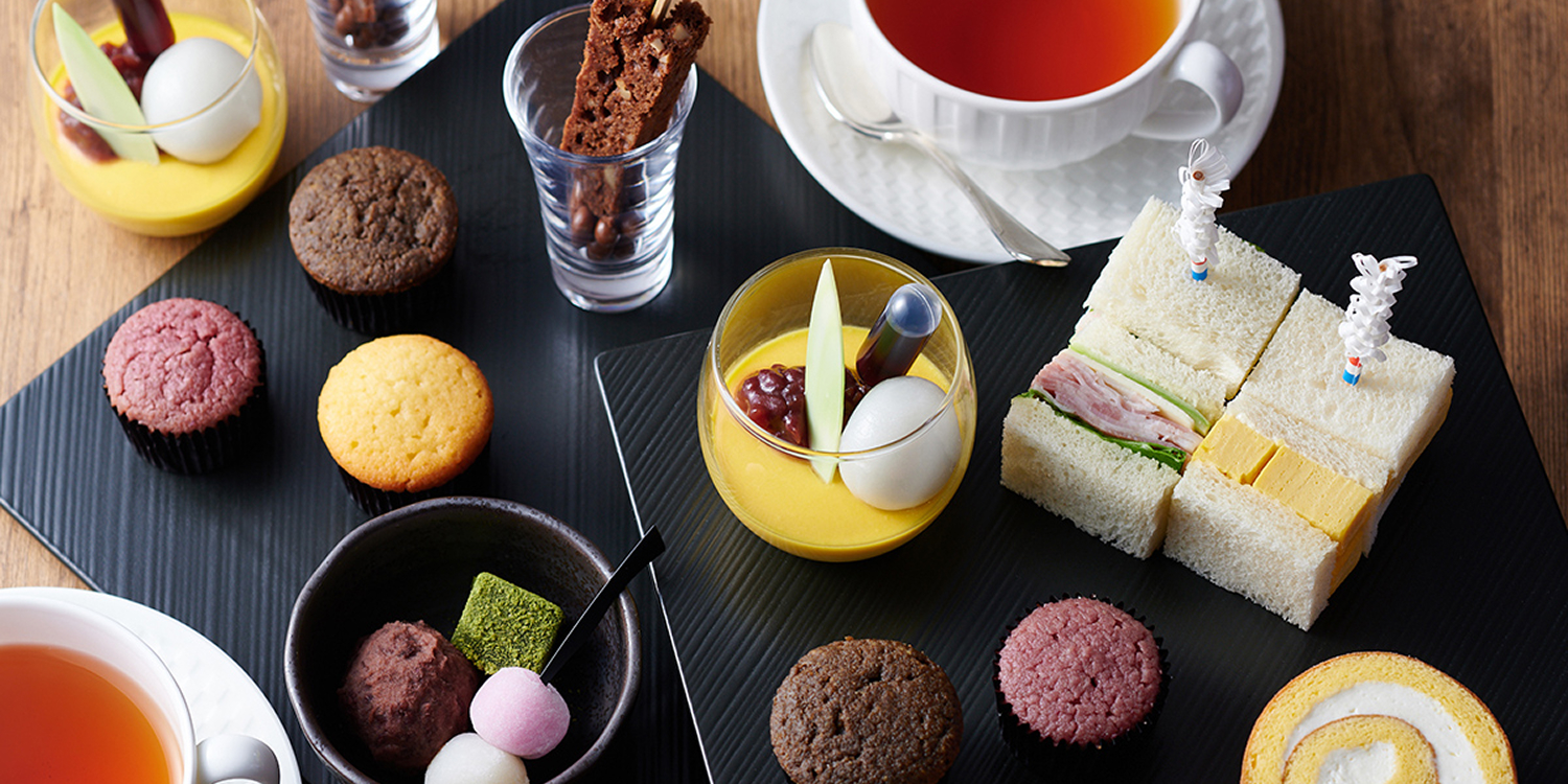 テーブルに並んだ紅茶やクッキー、ロールケーキやサンドイッチ。