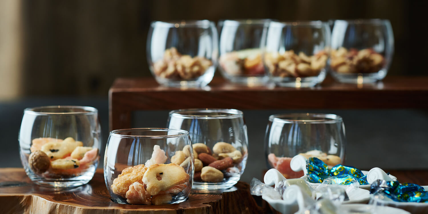 小さな器に入ったナッツやあられなどのスナック。