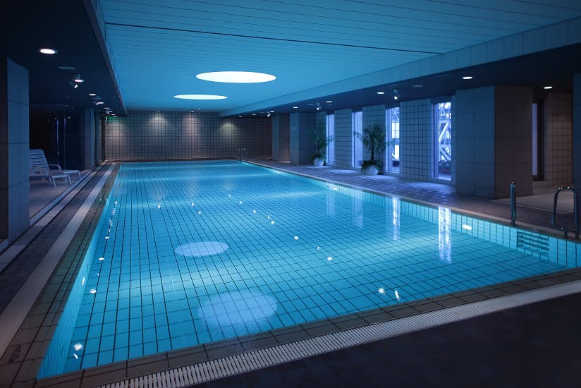 青い照明で照らされた、落ち着いた雰囲気の屋内プール。