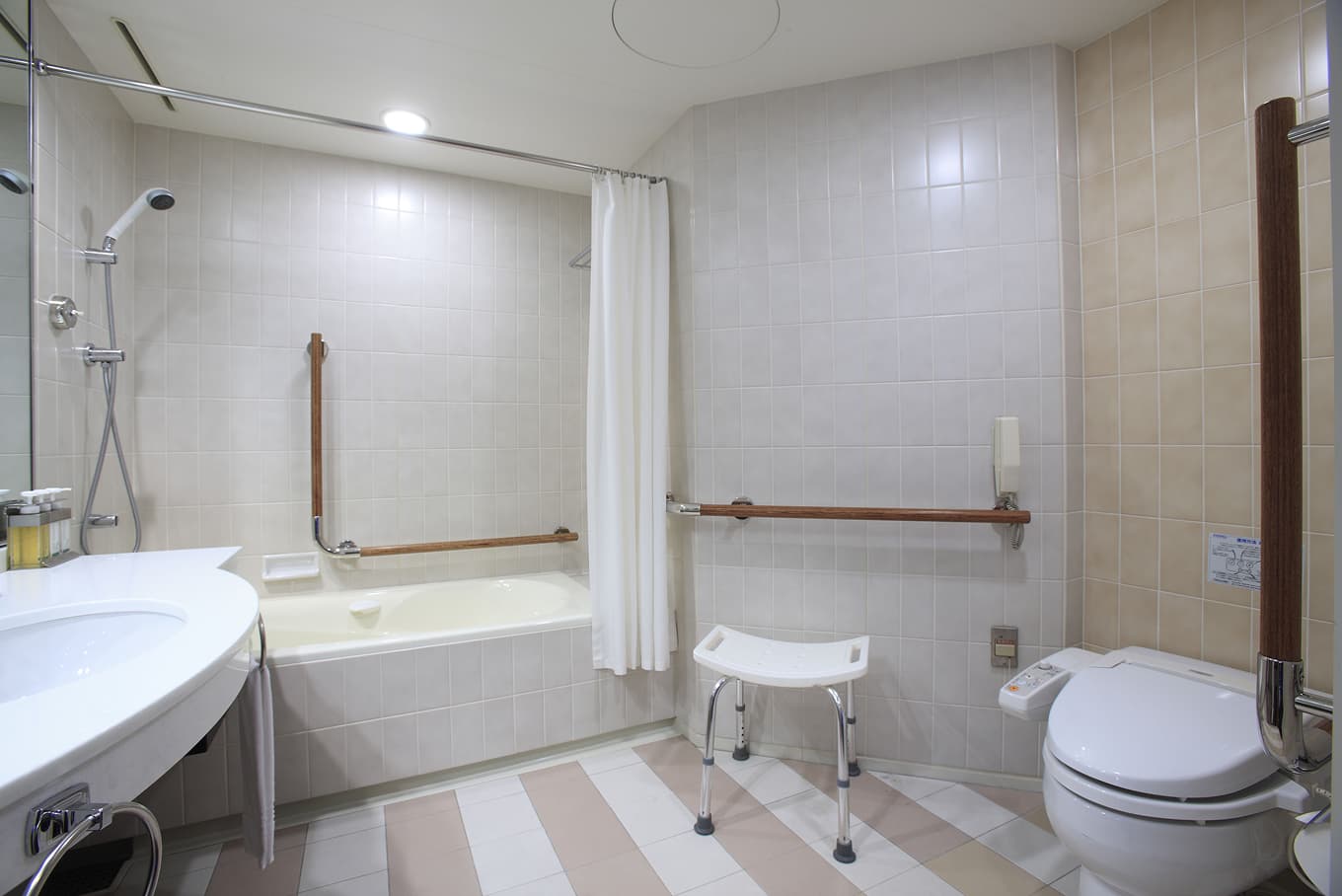 手すりが設置された広々としたホテルのバスルーム。