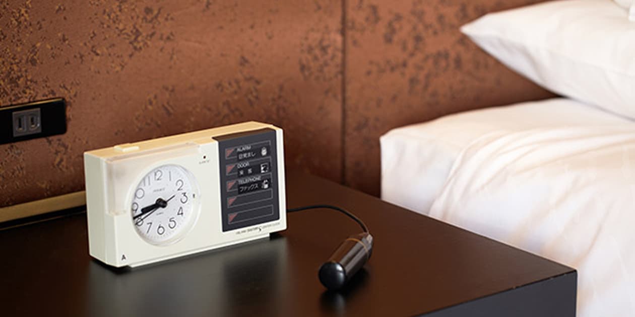 ベッドサイドテーブルに置かれたアラームと照明のスイッチ。