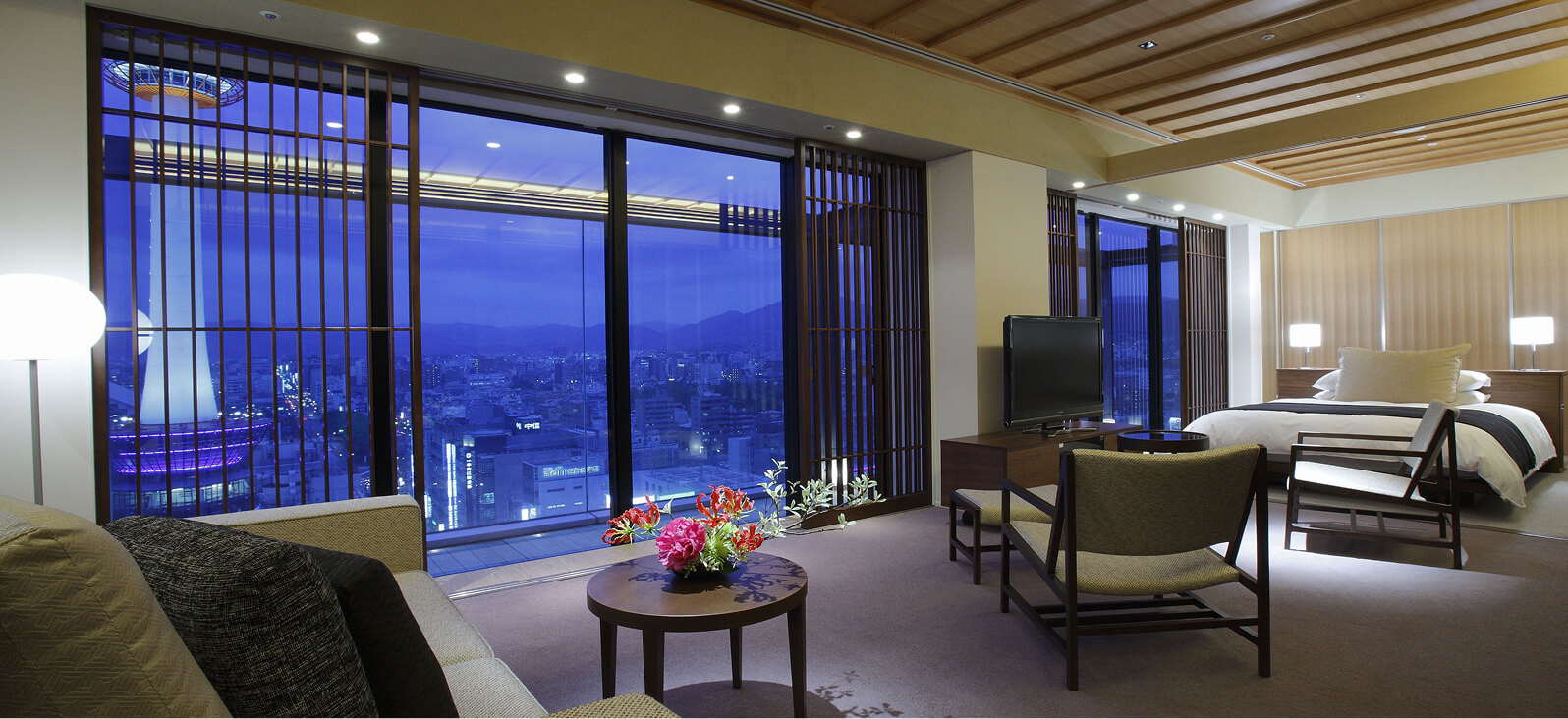 広い窓からの夜景が美しい、ソファとテーブルのある室内