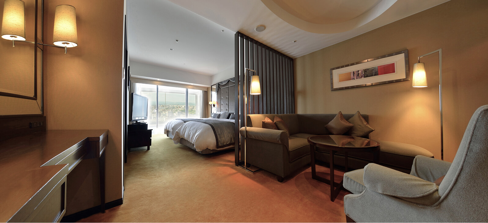 広々としたベッドルームとテーブル、障子風の間仕切りがある洋室