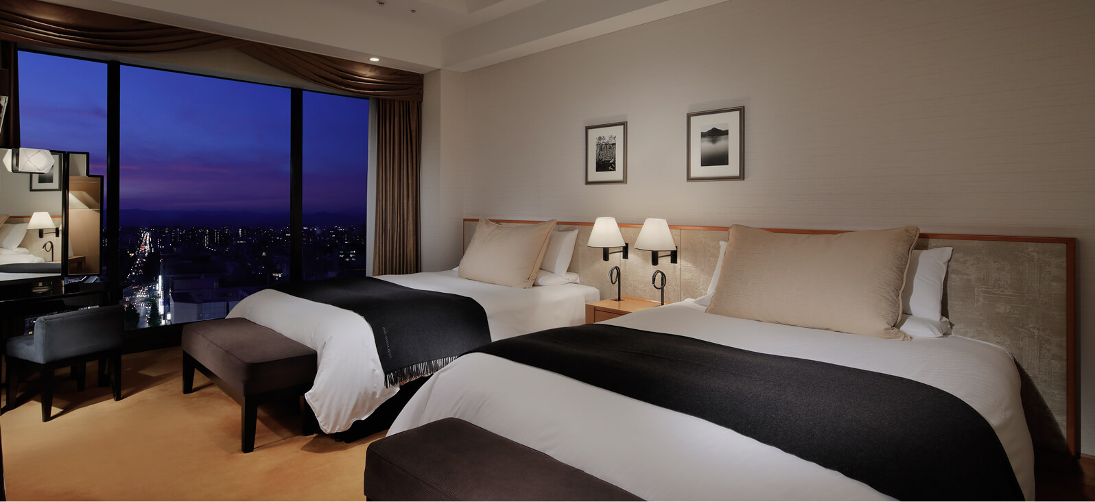 ツインベッドとソファ、テーブルがある上質な洋室