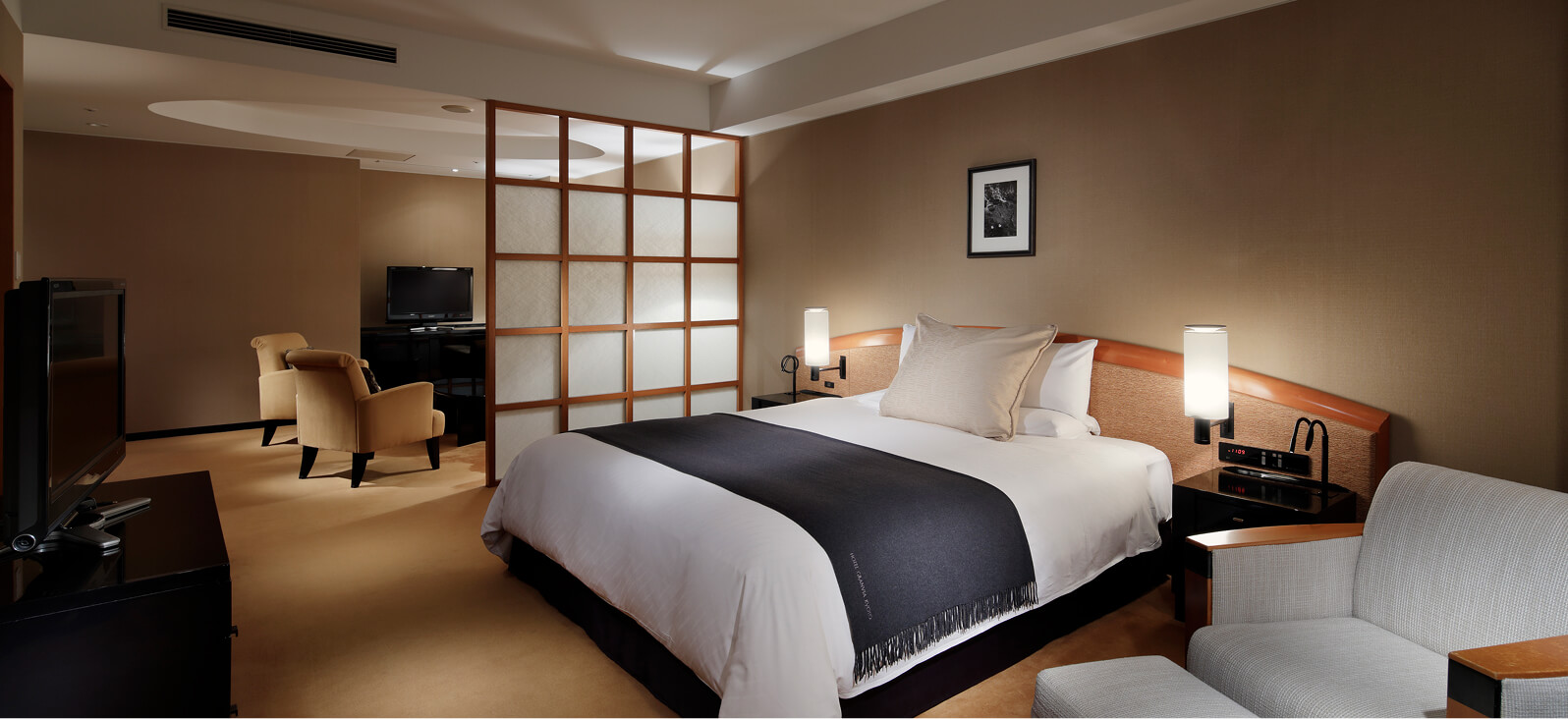 ダブルベッドとテーブルが配されたシンプルな洋室