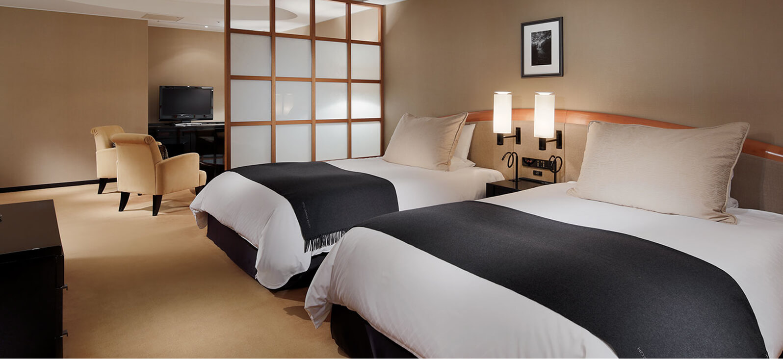 ツインベッドと障子風の間仕切りがある室内