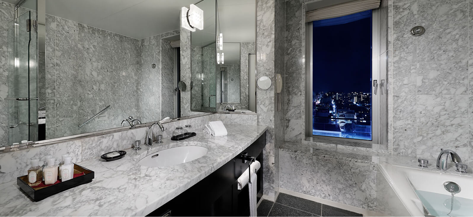 大理石調の洗面台とバスタブ付きのバスルーム