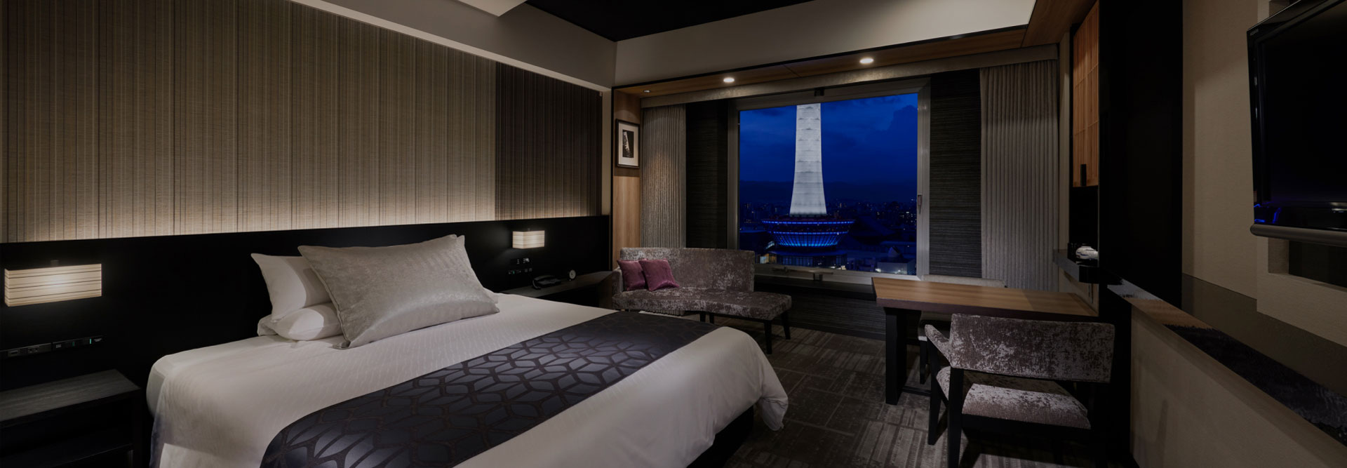 高層階からの夜景が広がる、モダンなデザインのダブルベッドルーム
