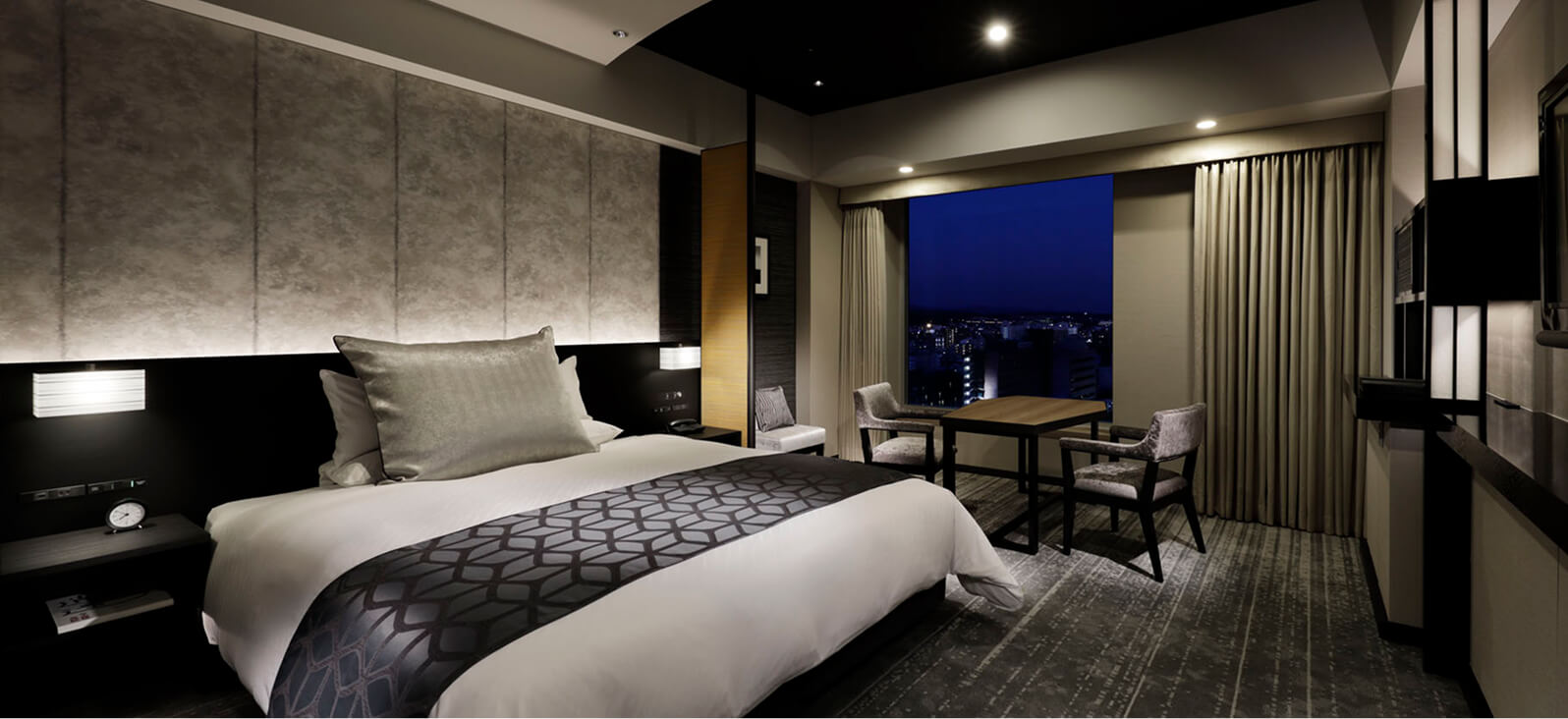 落ち着いた照明と都会的な雰囲気の、夜景が楽しめるダブルベッドルーム