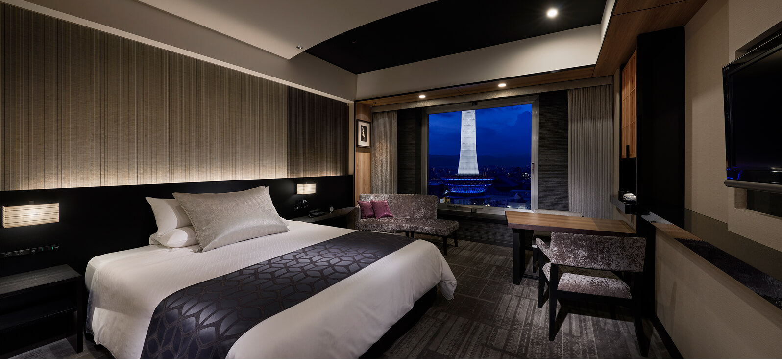 高層階からの夜景が広がる、モダンなデザインのダブルベッドルーム