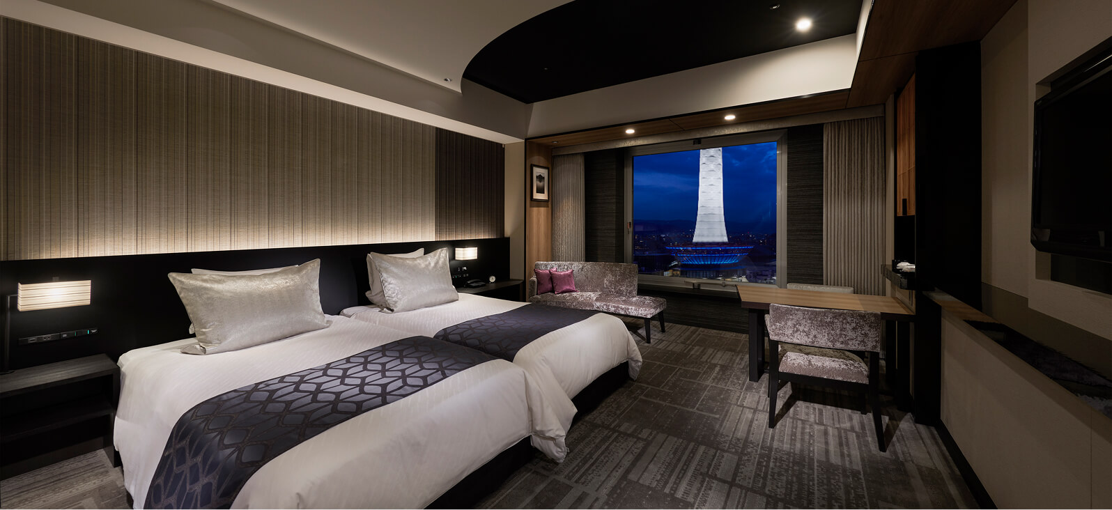 高層階からの夜景が広がる、ツインベッドルームの客室内観