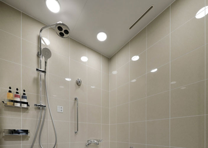 清潔感のあるバスルーム、壁掛けシャワーとアメニティ付き