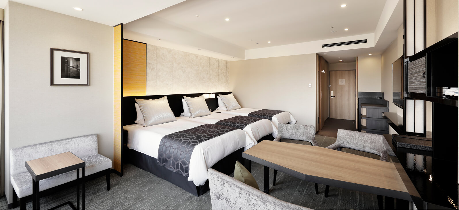 落ち着いた色合いでまとめられた、ソファとデスクのあるトリプルルーム